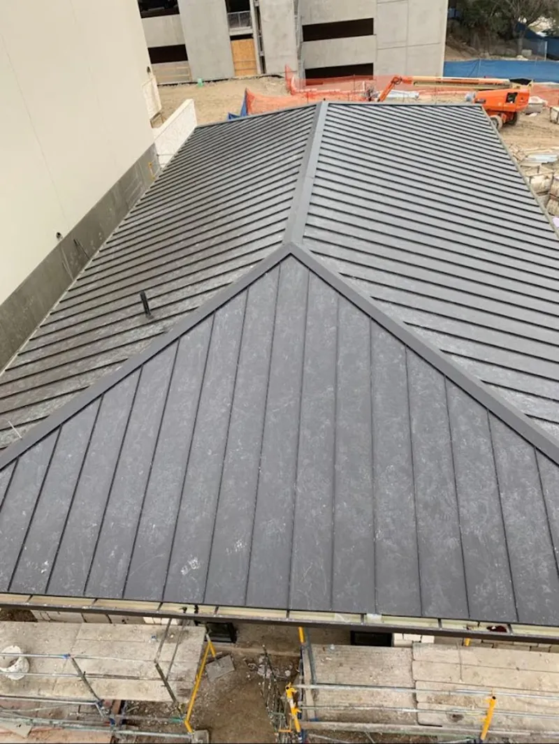 Commercial metal roof construction with crane equipment in Jackson